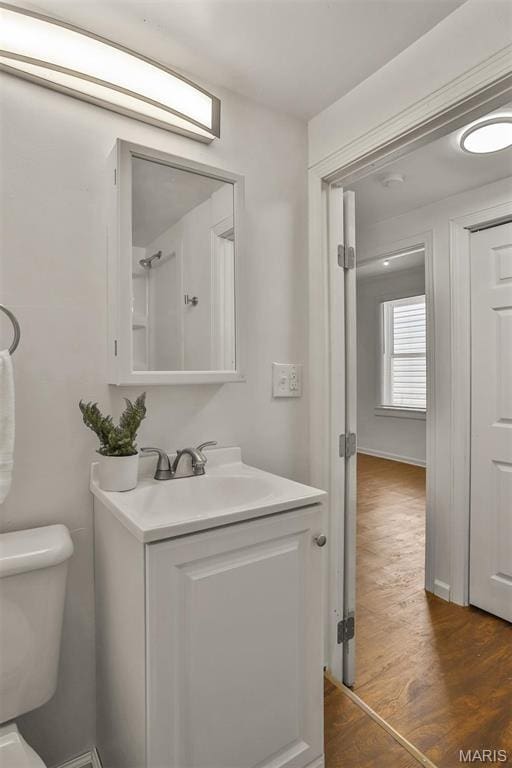 7613 Virginia Ave, Saint Louis, MO 63111 - bathroom featuring wood finished floors, toilet, and vanity