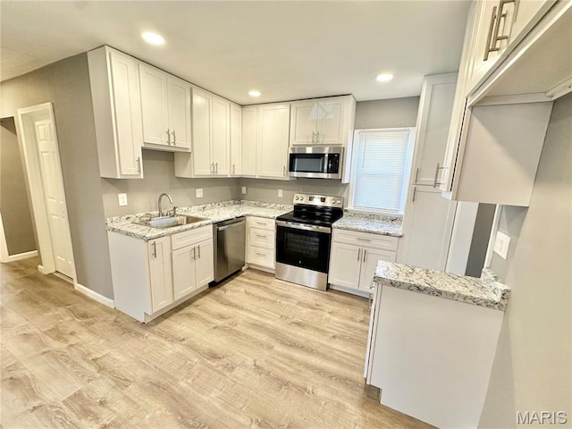 3345 Suncrest Ave, Saint Louis, MO 63114 - kitchen featuring stainless steel appliances, a sink, light stone countertops, white cabinetry, and recessed lighting