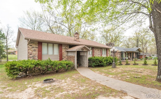 2018 Woodland Rd, Poplar Bluff, MO 63901 - view of front facade with a chimney, an outdoor fire pit, and brick siding