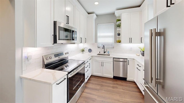 5714 Rhodes Ave, Saint Louis, MO 63109 - kitchen with stainless steel appliances, a sink, open shelves, decorative backsplash, and white cabinets