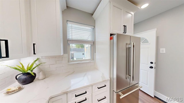 5714 Rhodes Ave, Saint Louis, MO 63109 - kitchen with high end refrigerator, white cabinetry, decorative backsplash, light stone counters, and wood finished floors