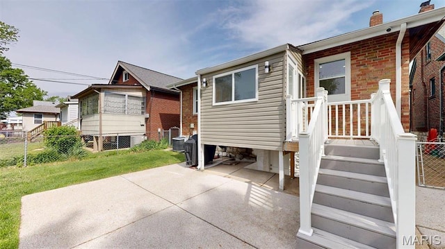 5714 Rhodes Ave, Saint Louis, MO 63109 - back of house featuring a chimney, a patio area, and central air condition unit