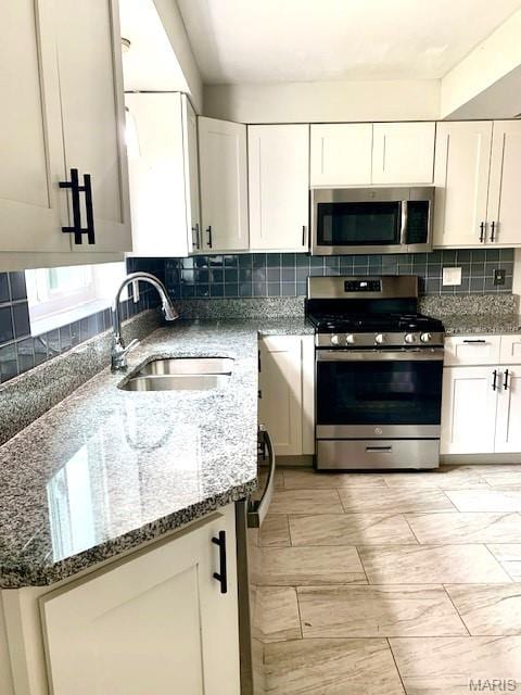 7026 Winona Ave, Saint Louis, MO 63109 - kitchen featuring stainless steel appliances, stone countertops, tasteful backsplash, and white cabinetry