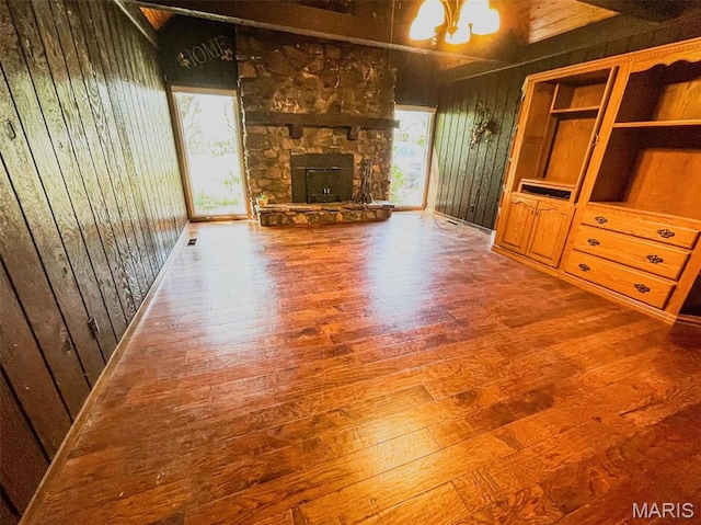 39988 Billy Blvd, Campbell, MO 63933 - unfurnished living room featuring hardwood / wood-style flooring, a fireplace, a chandelier, wood walls, and lofted ceiling