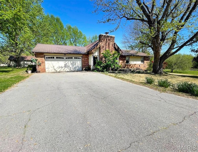 39988 Billy Blvd, Campbell, MO 63933 - view of front facade featuring driveway, a garage, a chimney, brick siding, and a front lawn