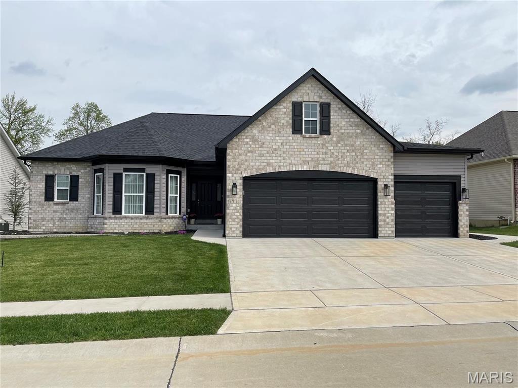1711 Sophia Grace Ln, Fenton, MO 63026 - french country home featuring driveway, a front yard, brick siding, and a garage