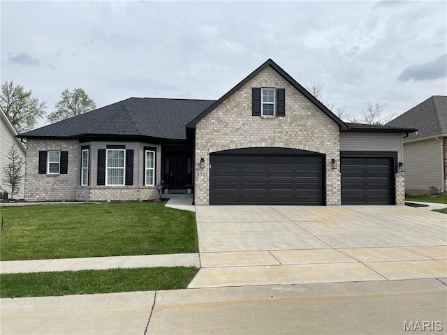 1711 Sophia Grace Ln, Fenton, MO 63026 - french country home featuring driveway, a front yard, brick siding, and a garage