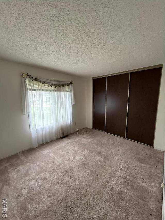 6919 Glenvale Ct, Florissant, MO 63033 - unfurnished bedroom with carpet flooring, a textured ceiling, and a closet