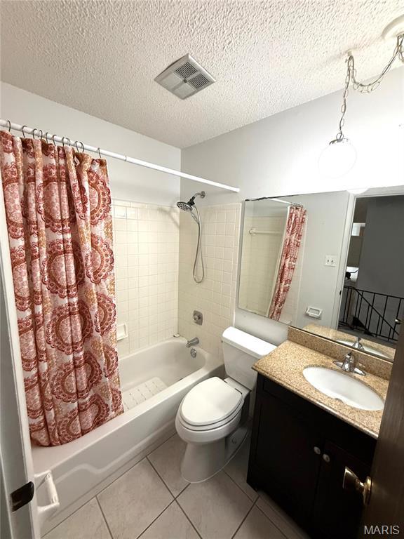6919 Glenvale Ct, Florissant, MO 63033 - full bathroom with shower / tub combo, tile patterned floors, a textured ceiling, toilet, and vanity