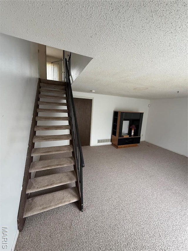 6919 Glenvale Ct, Florissant, MO 63033 - staircase featuring a textured ceiling and carpet floors