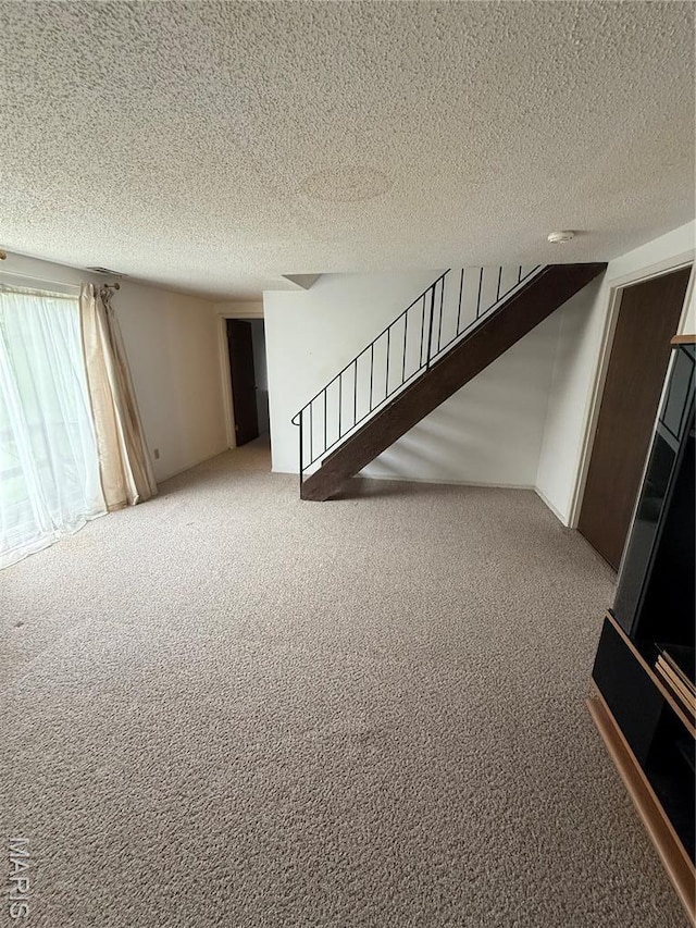 6919 Glenvale Ct, Florissant, MO 63033 - unfurnished living room featuring carpet floors, stairs, and a textured ceiling