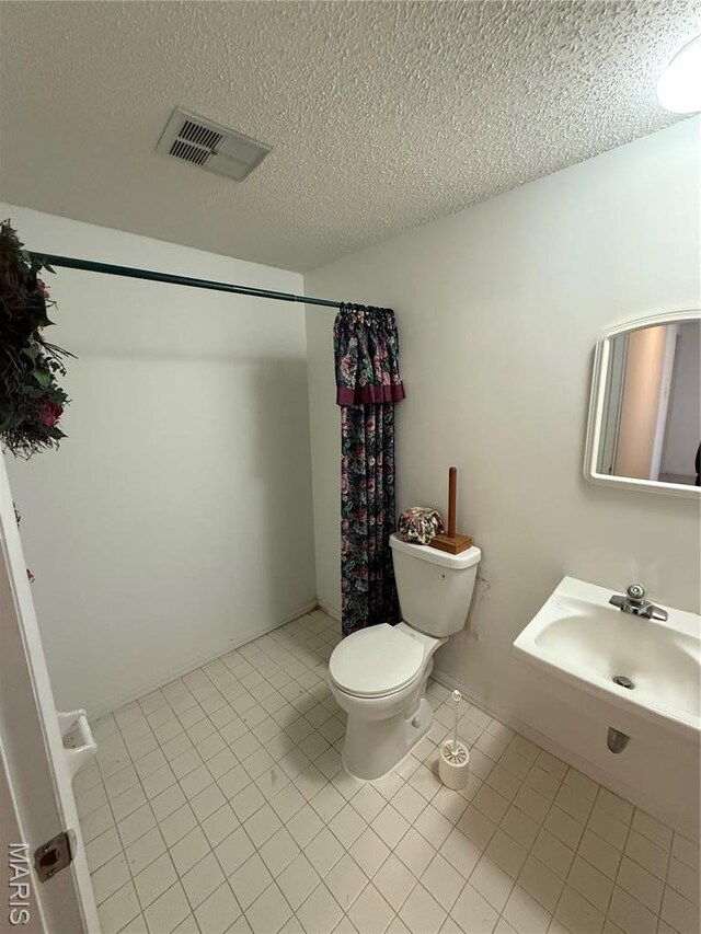 6919 Glenvale Ct, Florissant, MO 63033 - full bath with toilet, tile patterned floors, curtained shower, a textured ceiling, and a sink