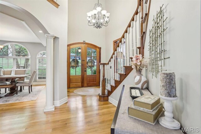 1002 Chesterfield Forest Dr, Wildwood, MO 63005 - entryway featuring french doors, arched walkways, light wood finished floors, ornate columns, and stairway