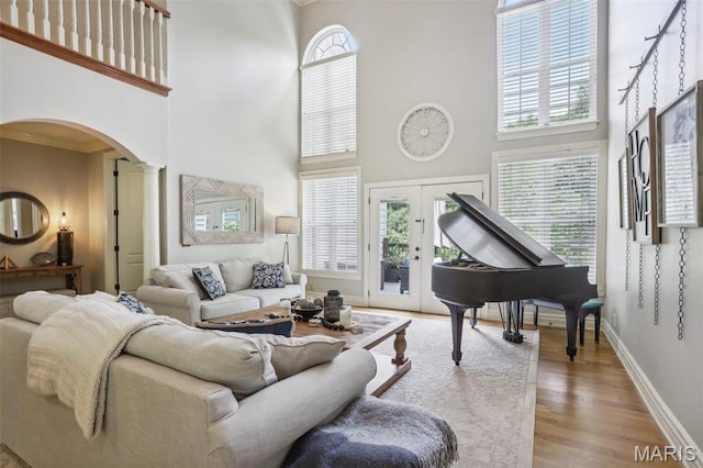 1002 Chesterfield Forest Dr, Wildwood, MO 63005 - living room with a high ceiling, arched walkways, wood finished floors, baseboards, and ornate columns