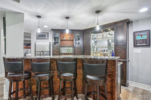 1002 Chesterfield Forest Dr, Wildwood, MO 63005 - indoor wet bar featuring stainless steel appliances, baseboards, light wood-type flooring, pendant lighting, and recessed lighting
