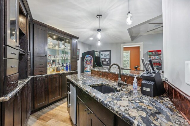 1002 Chesterfield Forest Dr, Wildwood, MO 63005 - kitchen featuring a sink, dark brown cabinets, hanging light fixtures, and stone counters