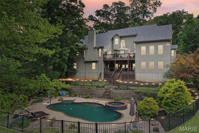 1002 Chesterfield Forest Dr, Wildwood, MO 63005 - back of house at dusk with stairs, a wooden deck, fence, a shingled roof, and a chimney