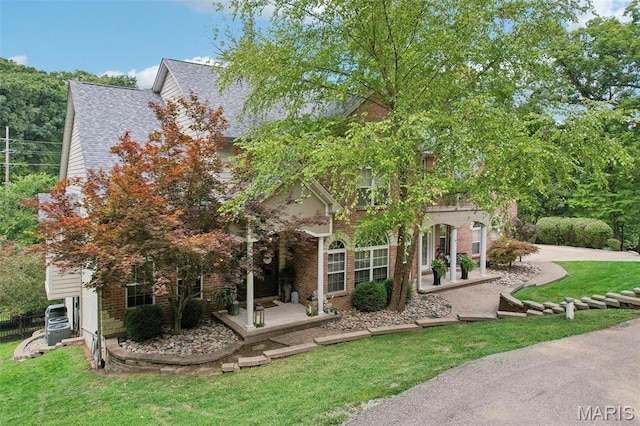 1002 Chesterfield Forest Dr, Wildwood, MO 63005 - view of property hidden behind natural elements featuring a front lawn, a porch, and a shingled roof
