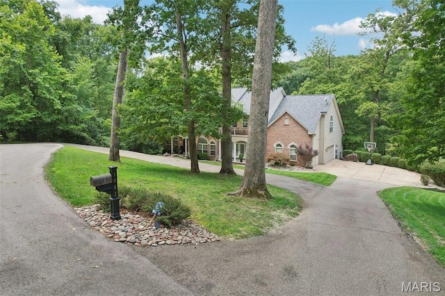 1002 Chesterfield Forest Dr, Wildwood, MO 63005 - view of front of home with curved driveway, a garage, brick siding, and a front yard