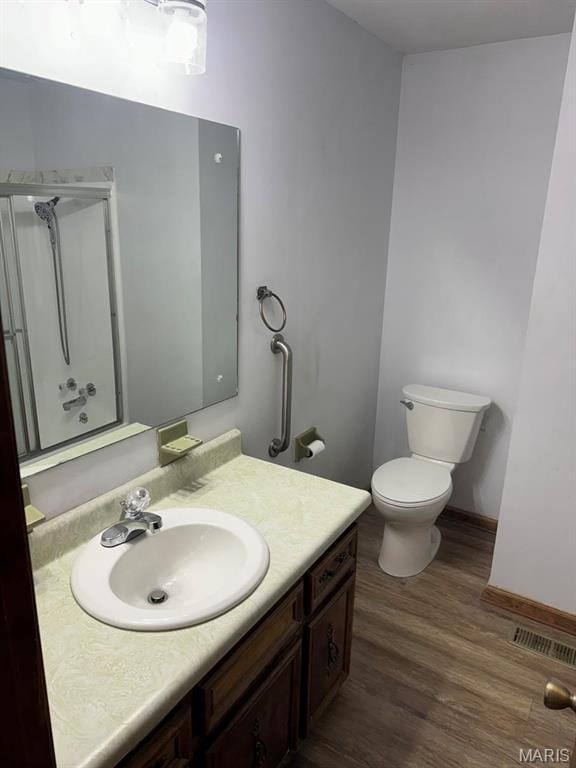 2925 Wayne Ave, Poplar Bluff, MO 63901 - bathroom featuring vanity, wood finished floors, a shower with door, toilet, and baseboards