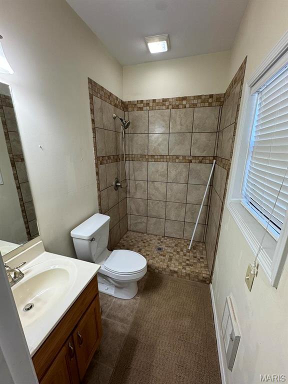 2925 Wayne Ave, Poplar Bluff, MO 63901 - bathroom with toilet, tiled shower, vanity, and healthy amount of natural light
