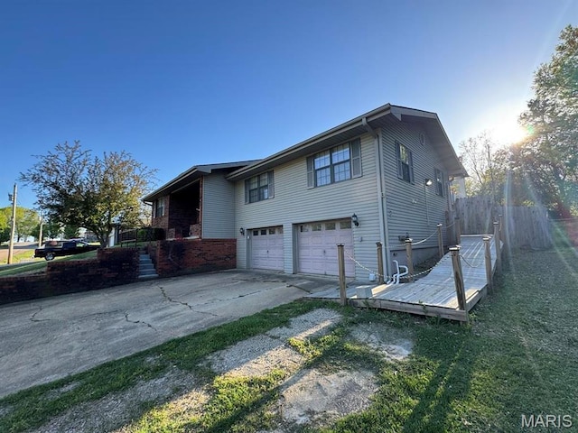 2925 Wayne Ave, Poplar Bluff, MO 63901 - view of side of home with an attached garage, concrete driveway, and fence