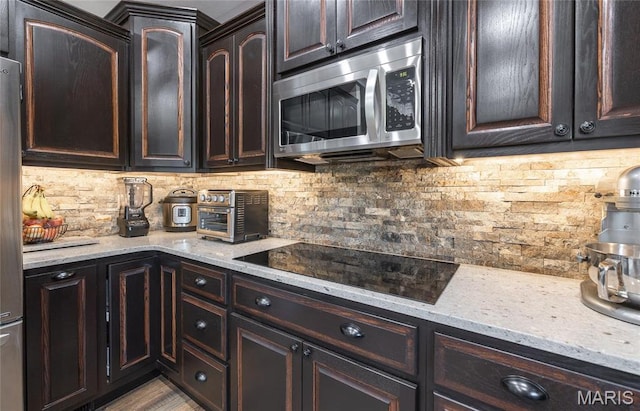 1100 Landon Rd, Bourbon, MO 65441 - kitchen featuring appliances with stainless steel finishes, decorative backsplash, and light stone countertops