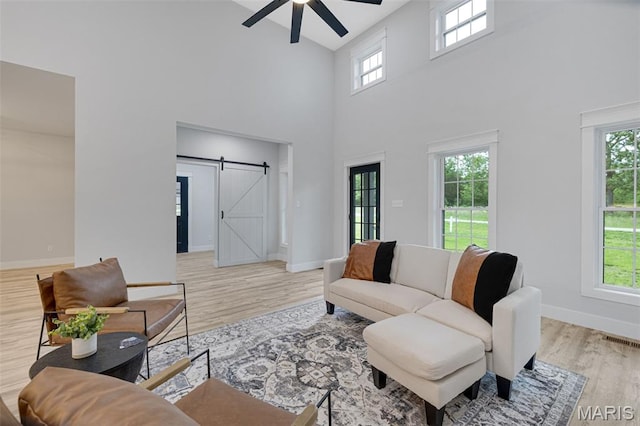 10102 Springer Dr, Bonne Terre, MO 63628 - living room featuring a barn door, a high ceiling, ceiling fan, wood finished floors, and baseboards