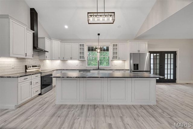 10102 Springer Dr, Bonne Terre, MO 63628 - kitchen with appliances with stainless steel finishes, wall chimney range hood, vaulted ceiling, a kitchen island, and white cabinets