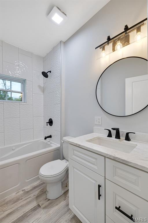 10102 Springer Dr, Bonne Terre, MO 63628 - full bathroom featuring toilet, wood finished floors, vanity, and washtub / shower combination