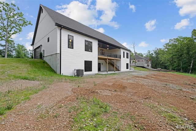 10102 Springer Dr, Bonne Terre, MO 63628 - back of property with a wooden deck, stairs, central air condition unit, a shingled roof, and dirt driveway