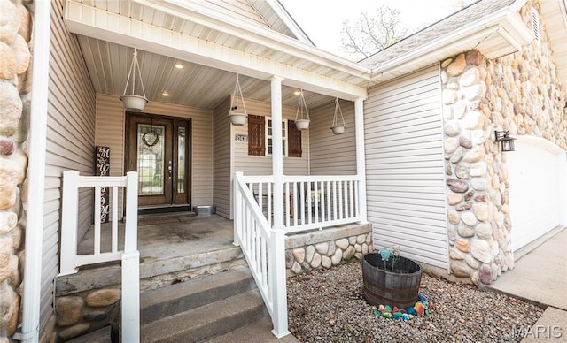 21438 Lancaster Ln, Waynesville, MO 65583 - view of exterior entry featuring a porch, stone siding, a garage, and a shingled roof