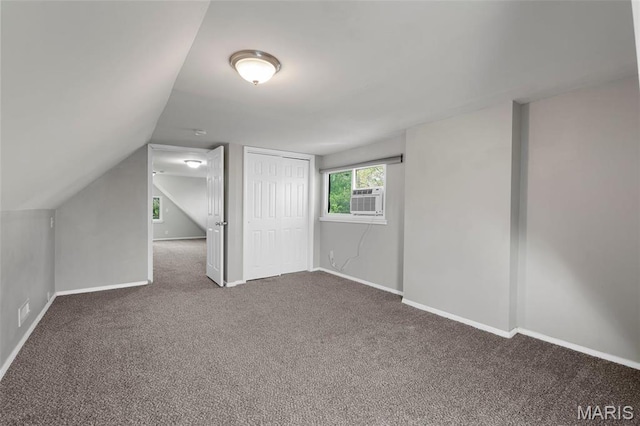 additional living space with carpet flooring, baseboards, lofted ceiling, and cooling unit