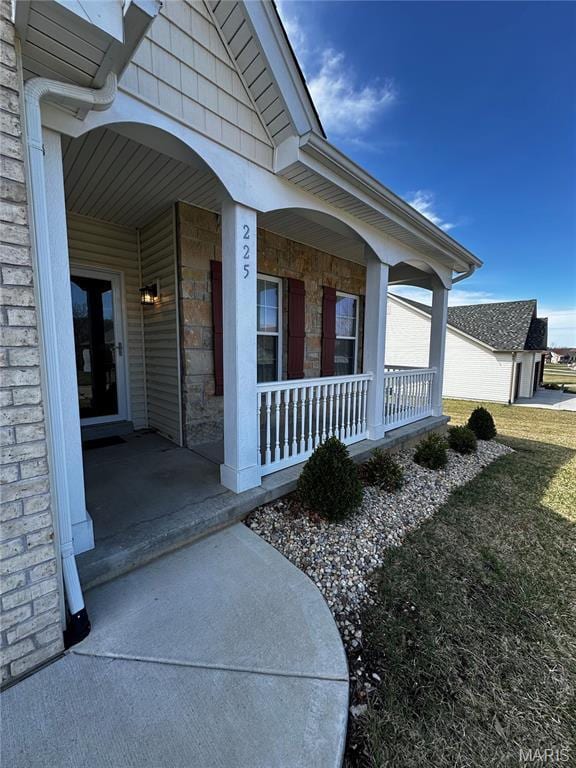 property entrance with covered porch and stone siding