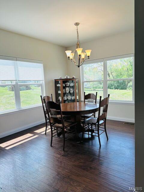 dining room featuring a chandelier, baseboards, and dark wood-style floors