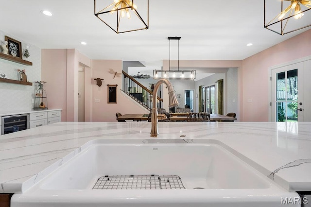 2509 Prairie Hollow Rd, Imperial, MO 63052 - kitchen view of a chandelier, a sink, beverage cooler, light stone counters, and pendant lighting