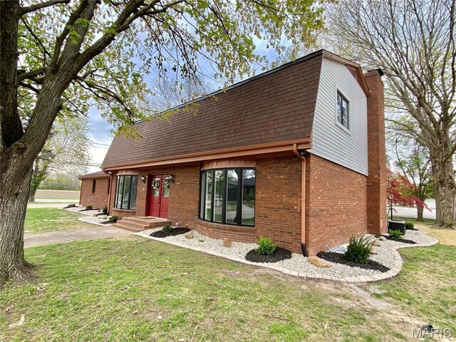2344 Arnold Dr, Granite City, IL 62040 - view of front of house featuring a gambrel roof, brick siding, a chimney, a front lawn, and roof with shingles