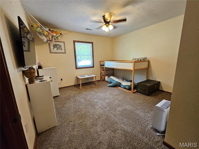 bedroom with carpet flooring, a textured ceiling, and a ceiling fan