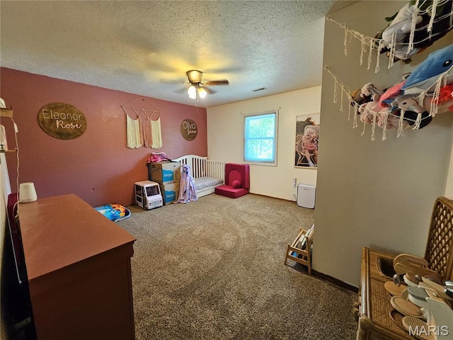 rec room with ceiling fan, carpet, and a textured ceiling