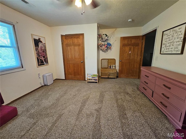 unfurnished room featuring carpet, ceiling fan, and a textured ceiling