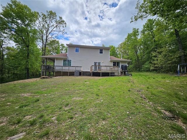 rear view of property with central AC unit, a wooden deck, and a lawn
