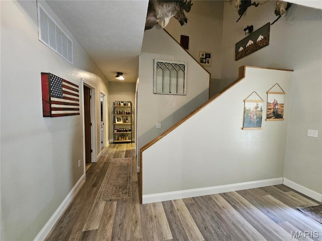 stairway with wood finished floors and baseboards