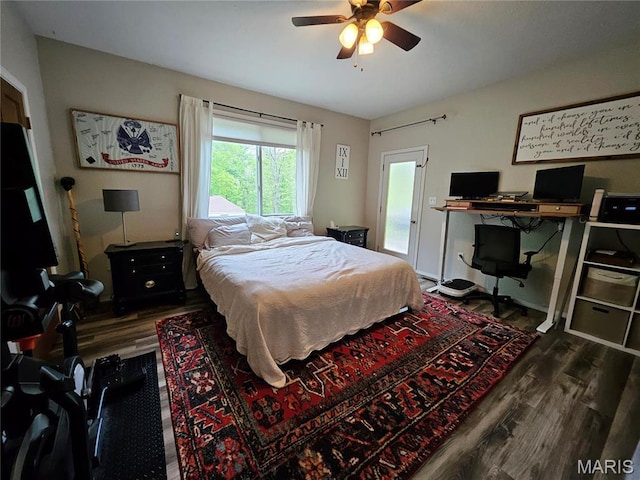 bedroom with dark wood-style flooring, a desk, and ceiling fan