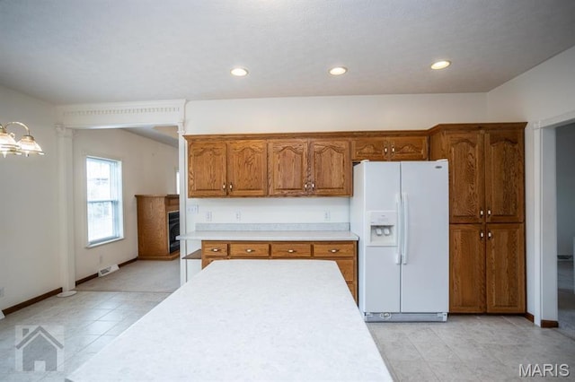 220 April Dr, Saint Robert, MO 65584 - kitchen featuring white fridge with ice dispenser, light countertops, brown cabinets, recessed lighting, and light tile patterned flooring