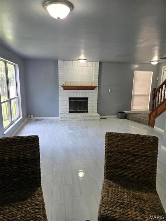 352 Sturbridge Village Dr, Hazelwood, MO 63042 - unfurnished living room featuring baseboards and a brick fireplace