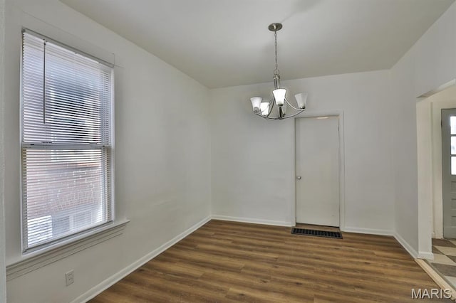 4417 Wallace St, Saint Louis, MO 63116 - unfurnished dining area with a chandelier, dark wood-style flooring, and baseboards