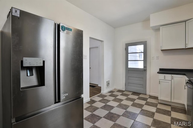 4417 Wallace St, Saint Louis, MO 63116 - kitchen featuring stainless steel appliances, baseboards, tile patterned floors, dark countertops, and white cabinetry