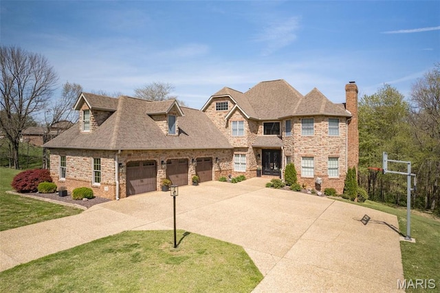 312 Oak Forest Dr, Jackson, MO 63755 - view of front facade featuring driveway, a chimney, a front lawn, and a garage