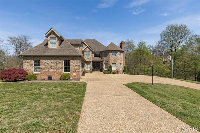 312 Oak Forest Dr, Jackson, MO 63755 - view of front of house with concrete driveway, a front lawn, a chimney, and brick siding