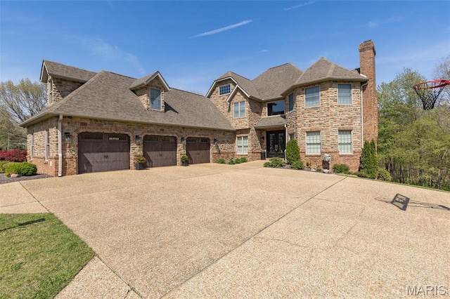 312 Oak Forest Dr, Jackson, MO 63755 - view of front facade featuring concrete driveway, a garage, stone siding, a chimney, and roof with shingles